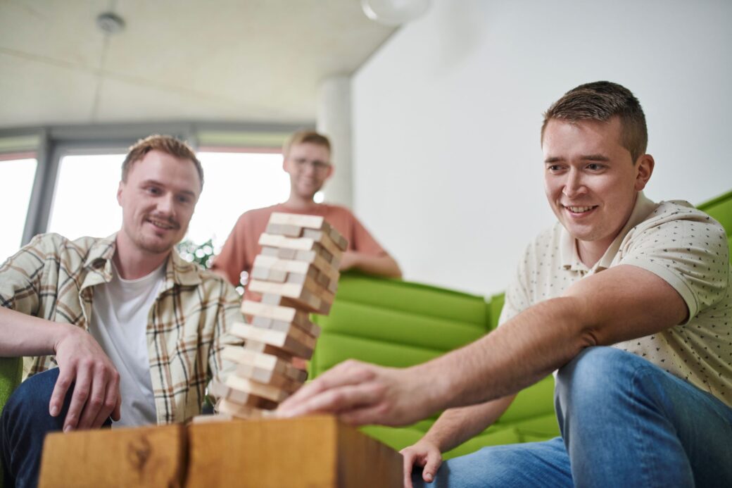 Drei Mitarbeiter spielen gemeinsam Jenga