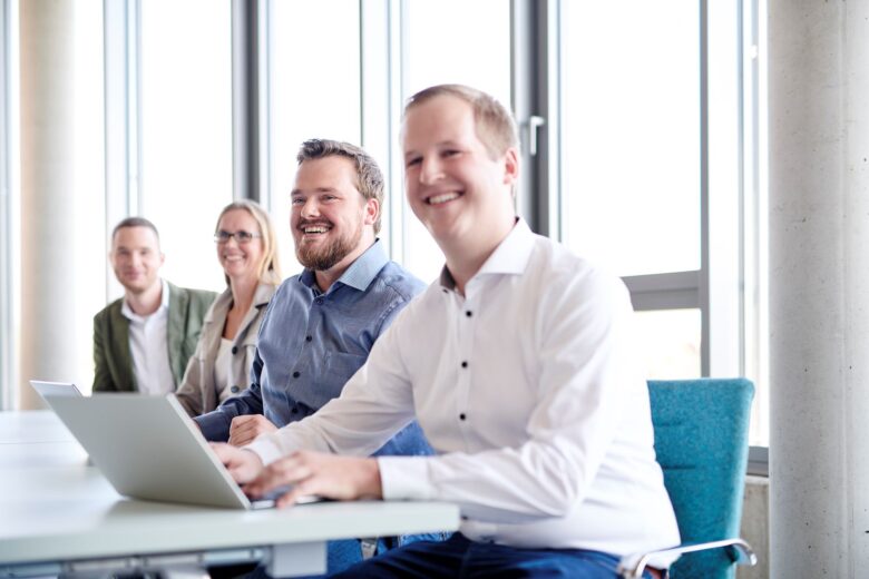 Employees from technical services sit together and talk about their system landscape.