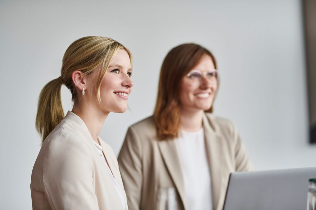 Two employees smile while having a conversation (walk & talk)